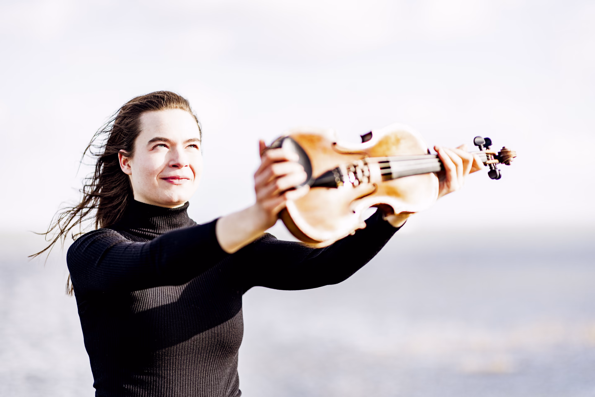 Hadewych outside holding violin against the wind